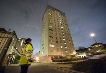 A police officer looks up at the Marine Tower block of flats in Deptford, London, following a fire.