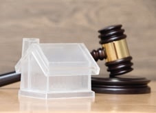 Pic of judge's gavel behind a plastic house